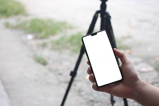 As mãos de um homem de negócios que guardam um smartphone vazio e têm o espaço da cópia.