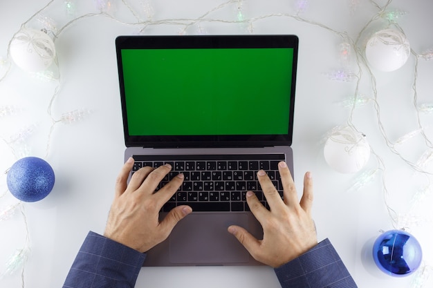 as mãos de um homem e um laptop com tela verde