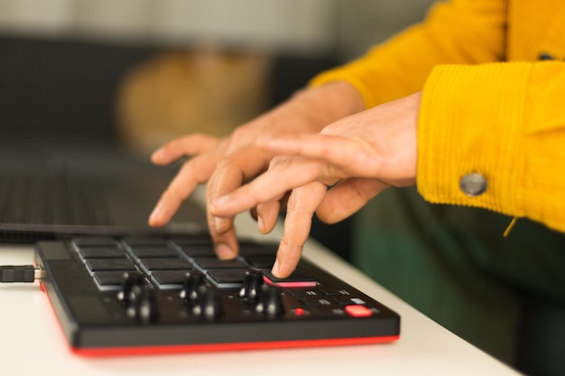 As mãos de um homem fazendo batidas em seu controlador MPD MIDI