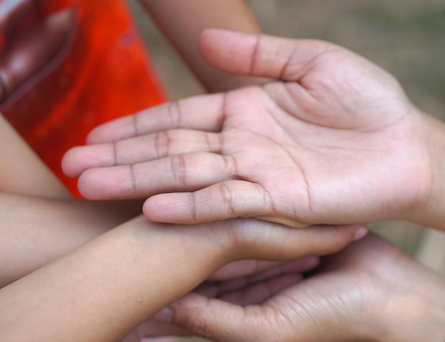 As mãos de uma criança e uma mãe unem forças