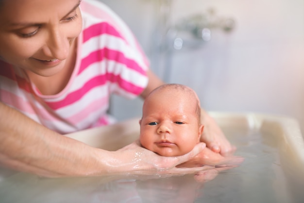 As mãos de uma mãe cuidadosa seguram o menino