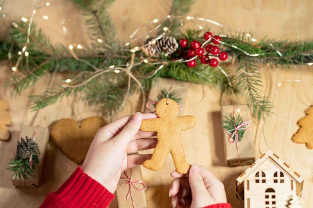 As mãos de uma menina seguram um boneco de gengibre, um elemento da decoração do calendário do advento do natal