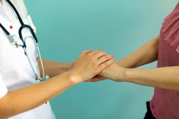 Foto as mãos do doutor fêmea que prendem a mão do paciente para o incentivo e a empatia. parceria, confiança e conceito de ética médica.