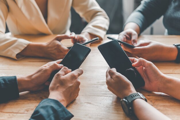As mãos do grupo de pessoas estão jogando em grupos móveis para navegar no mundo social online.