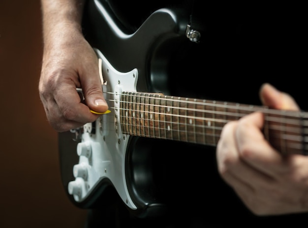 As mãos do homem tocando guitarra elétrica