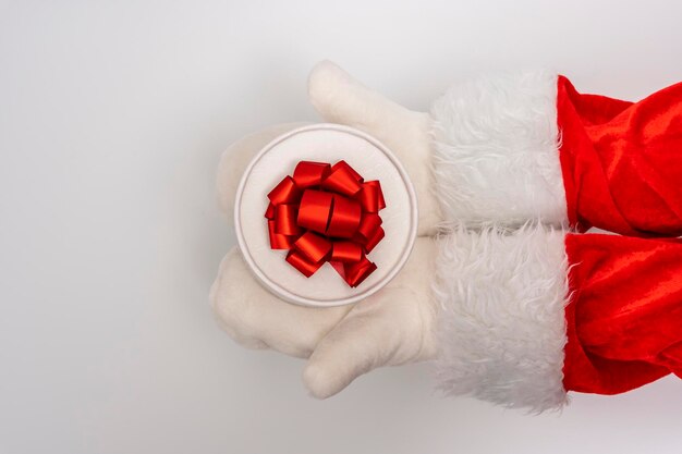 As mãos do Papai Noel estão segurando um presente para o fundo branco de Natal