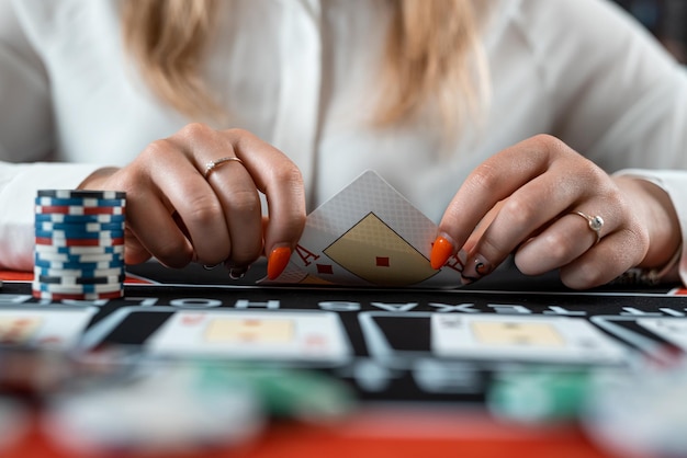 As mãos dos concessionários estão segurando pilhas de fichas de pôquer e jogando cartas de risco para ganhar