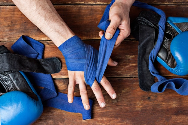 As mãos dos homens durante a gravação antes de uma luta de boxe contra um fundo de madeira.