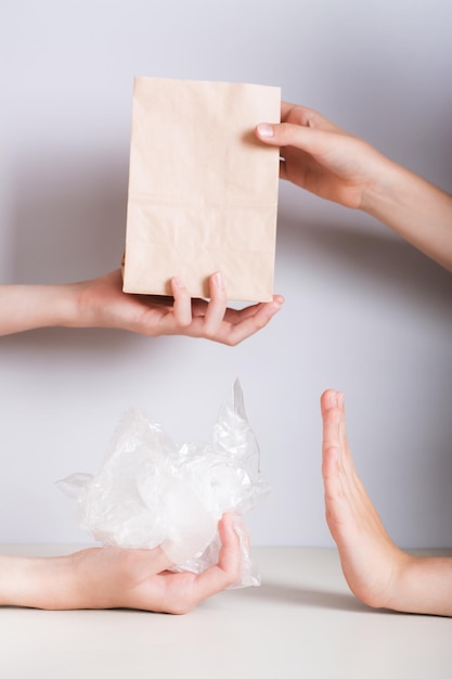As mãos escolhem o saco de papel ecológico e recusam a visão vertical do saco de plástico