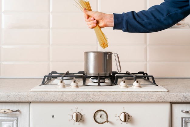 As mãos segurando um monte de espaguete cru e cozinhá-lo. macarrão tradicional italiano