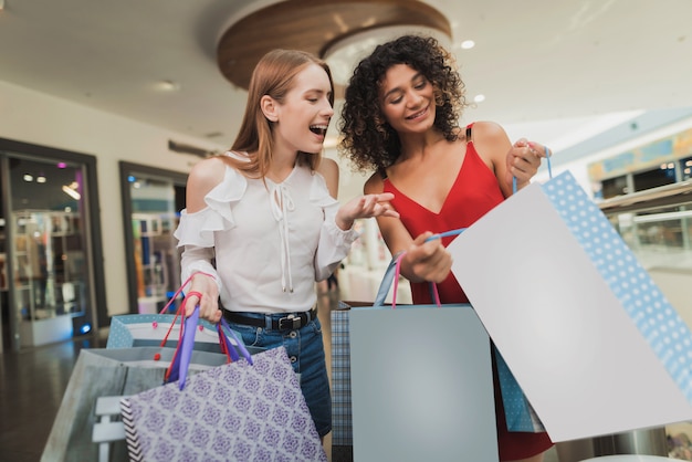 As meninas andam pelo shopping com novas compras.