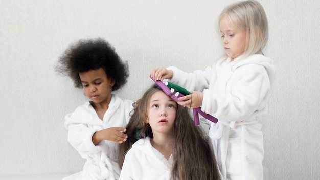 As meninas brincam com rolos de cabelo e grampos de cabelo.