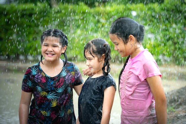 As meninas divertem-se a brincar na lama nos campos da comunidade.