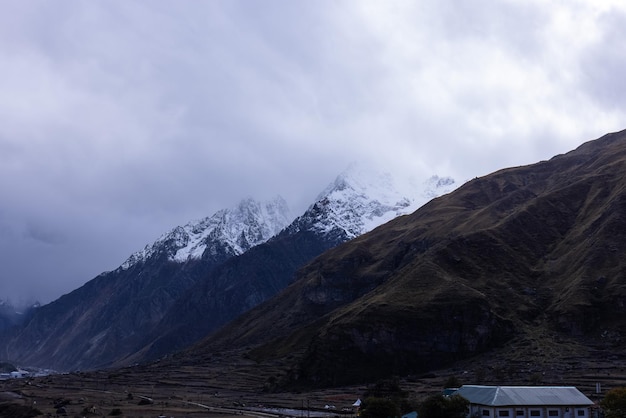 As montanhas estão cobertas de neve e as nuvens são visíveis.