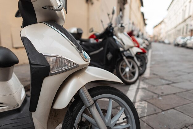 As motocicletas estão estacionadas na rua em uma cidade europeia na itália ciclomotores transporte urbano bicicletas