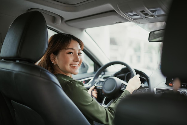 As mulheres asiáticas dirigir um carro e sorrir alegremente com expressão positiva feliz durante a viagem de carro