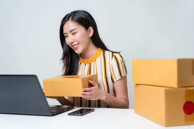 As mulheres asiáticas estão começando um novo negócio no mercado online. Mulheres asiáticas verificando produtos, preparando-se para entregar produtos aos clientes. Conceito PME