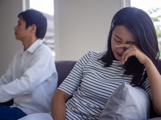 Foto as mulheres asiáticas estão desapontadas e tristes depois de uma discussão com o marido. casais asiáticos estão tendo problemas familiares, resultando em divórcio.
