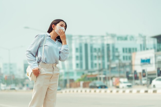 As mulheres asiáticas que usam máscara de proteção sentem dores de cabeça e tosse devido à poluição do ar PM 25 A poluição do ar causou problemas de saúde poluição ambiental