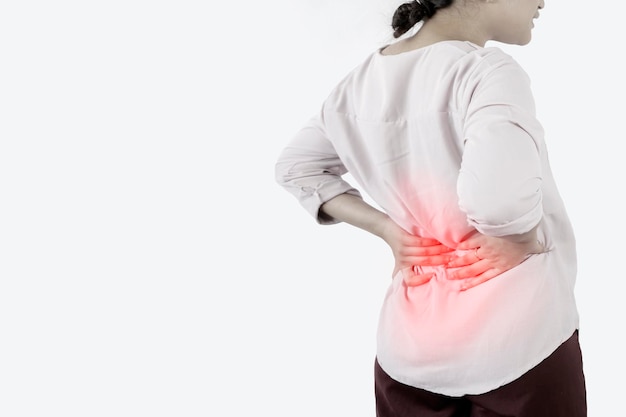 Foto as mulheres asiáticas são o conceito de dor nas costas inflamação do rim homem que sofre de dor nas costas em casa zona inflamada vermelha vestindo uma camisa branca fundo cinza
