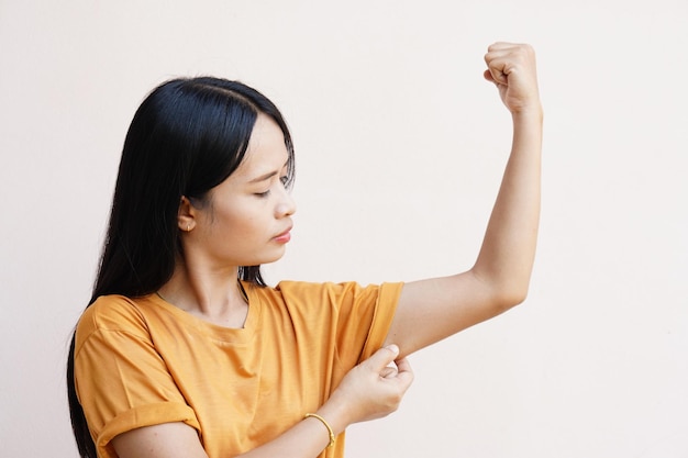 As mulheres asiáticas usam as mãos na pele sob os braços para ver se têm muita gordura ou flacidez