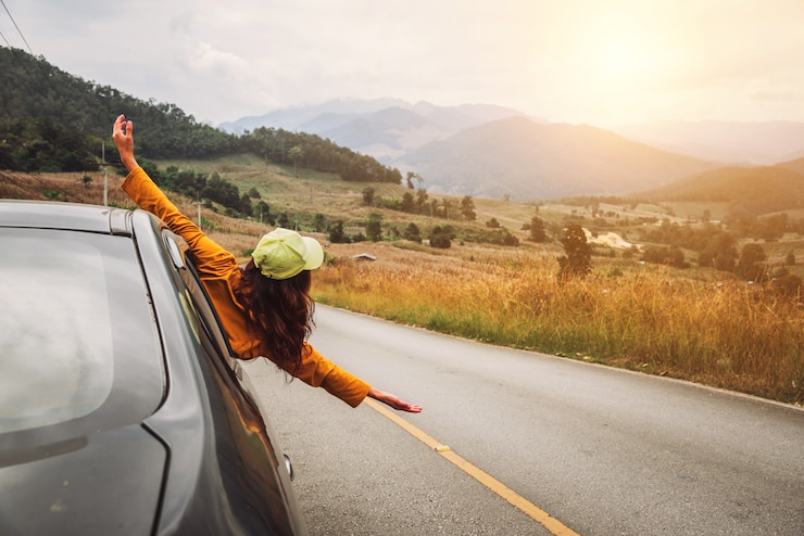 Foto as mulheres asiáticas viajam em um carro com meio corpo fora da janela.