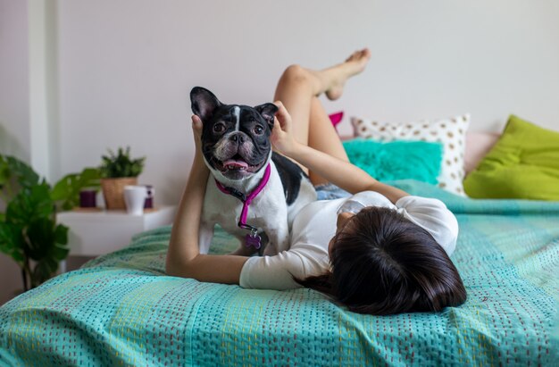 as mulheres brincam com cachorro no quarto