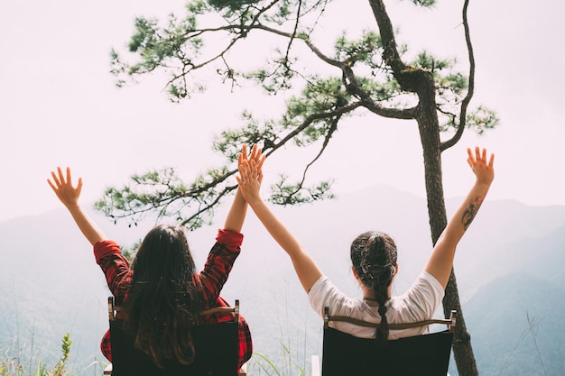 As mulheres do acampamento levantam as mãos para admirar o ar