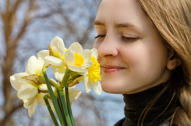 As mulheres jovens apreciam o buquê de narcisos, close-up