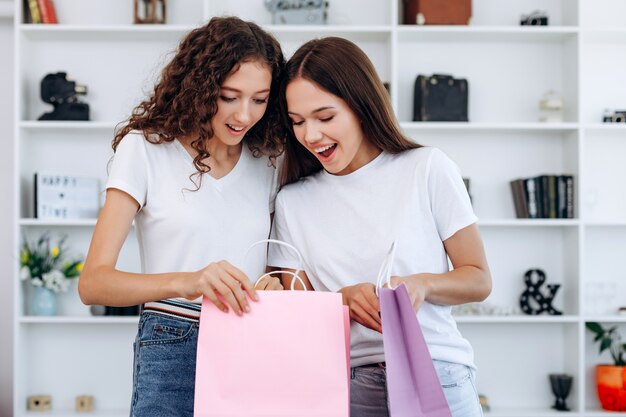 As mulheres jovens parecem surpresas com o pacote depois das compras