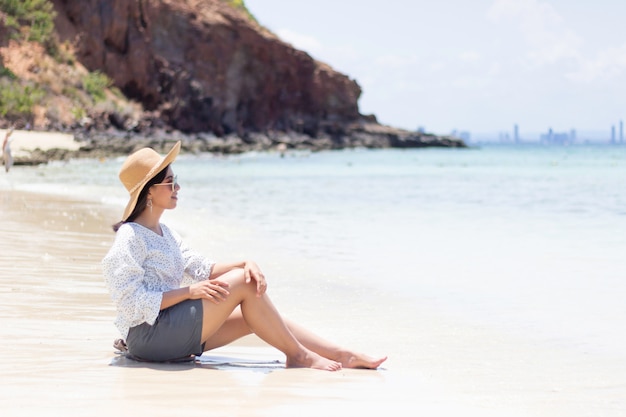 As mulheres jovens viajando relaxar na praia no verão