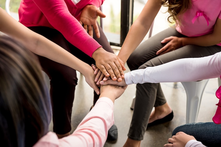 Foto as mulheres juntam as mãos na reunião de campanha de conscientização sobre o câncer de mama