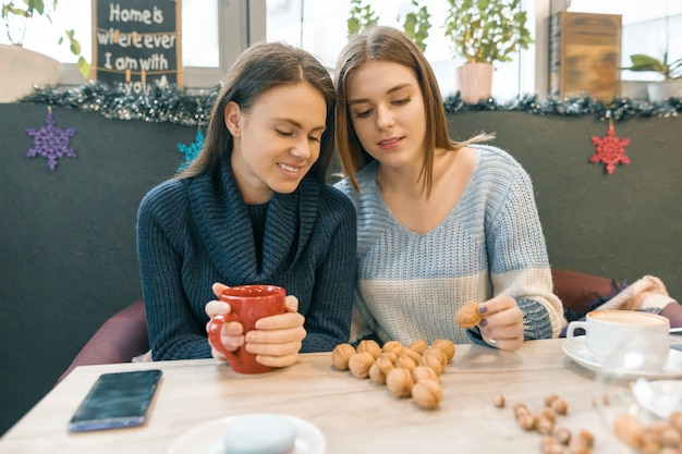 As mulheres no café bebem bebidas quentes