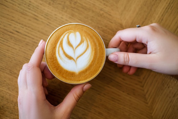 As mulheres seguram a xícara de café no fundo do café