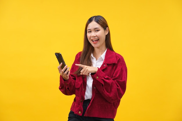 As mulheres usam smartphone para navegar nas mídias sociais e felicidade sorrindo sobre fundo amarelo isolado