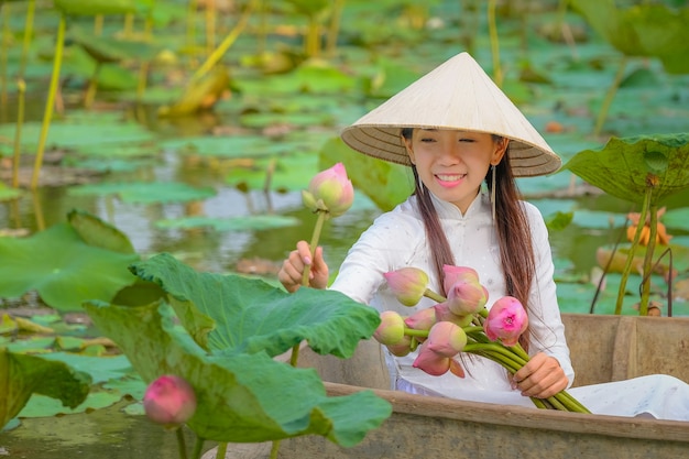 As mulheres vietnamitas estão recolhendo o loto no por do sol.