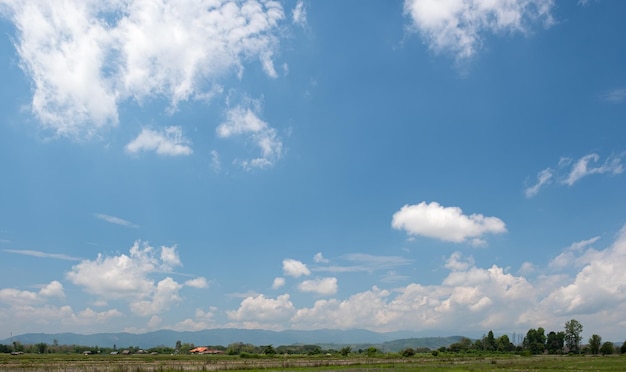 As nuvens brancas têm uma forma estranha e lado do campo Céu nublado e azul