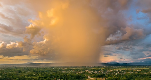 As nuvens de trovoada com a chuva ao pôr do sol em chiang mai tailândia