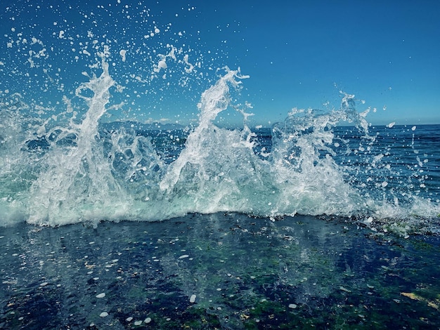 As ondas do mar a salpicar contra o céu azul