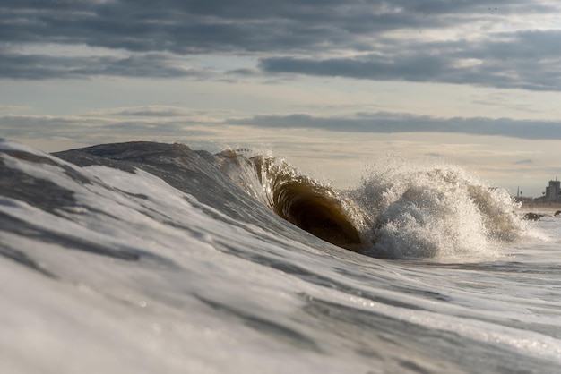 As ondas do mar a salpicar na costa contra o céu