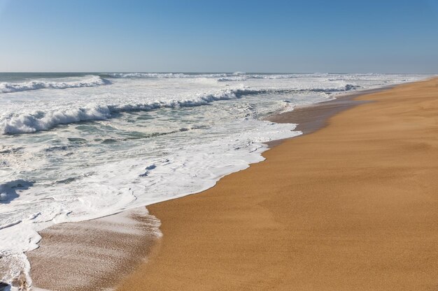 As ondas do mar cobrem a areia da praia