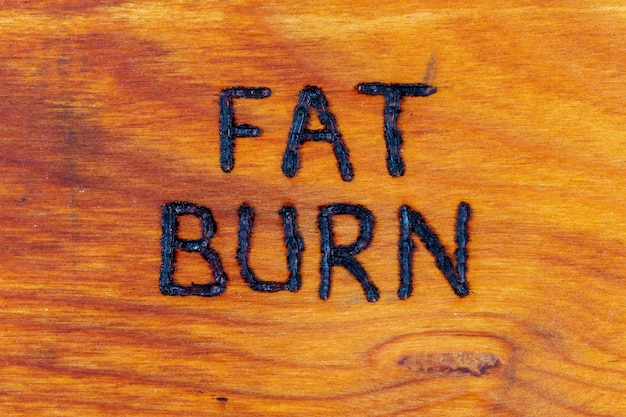 As palavras queimadura de gordura handritten na superfície de madeira com recuperador de calor