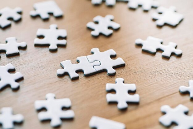 as peças do quebra-cabeça são conectadas peças de quebra-cabeça brancas em um parceiro de negócios de fundo de mesa de madeira