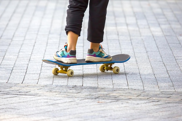 As pernas de um adolescente rolando em um skate