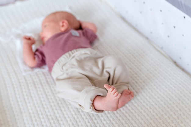 As pernas de um bebê recém-nascido em um cobertor branco