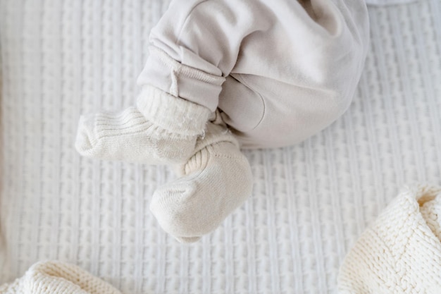 As pernas de um bebê recém-nascido em um cobertor branco