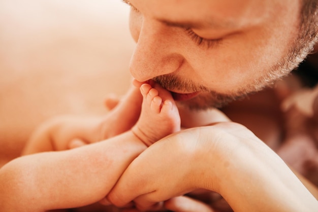 As pernas de um bebê recém-nascido nas mãos de seus pais