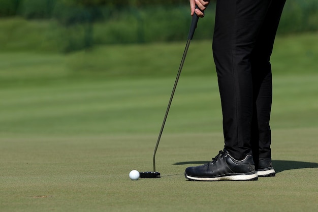 As pernas do jogador de golfe ficam na grama do campo de golfe