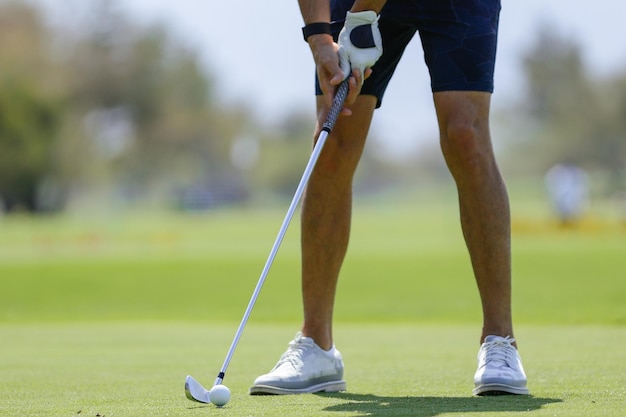 As pernas do jogador de golfe ficam na grama do campo de golfe