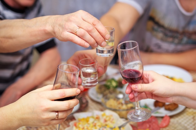 As pessoas bebem à mesa, clink copos. Saúde